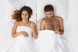 Buy Home from Sensual Extensions Penis Sleeves Indoor shot of unhappy frustrated bearded Caucasian man looking under white blanket at his penis, wo